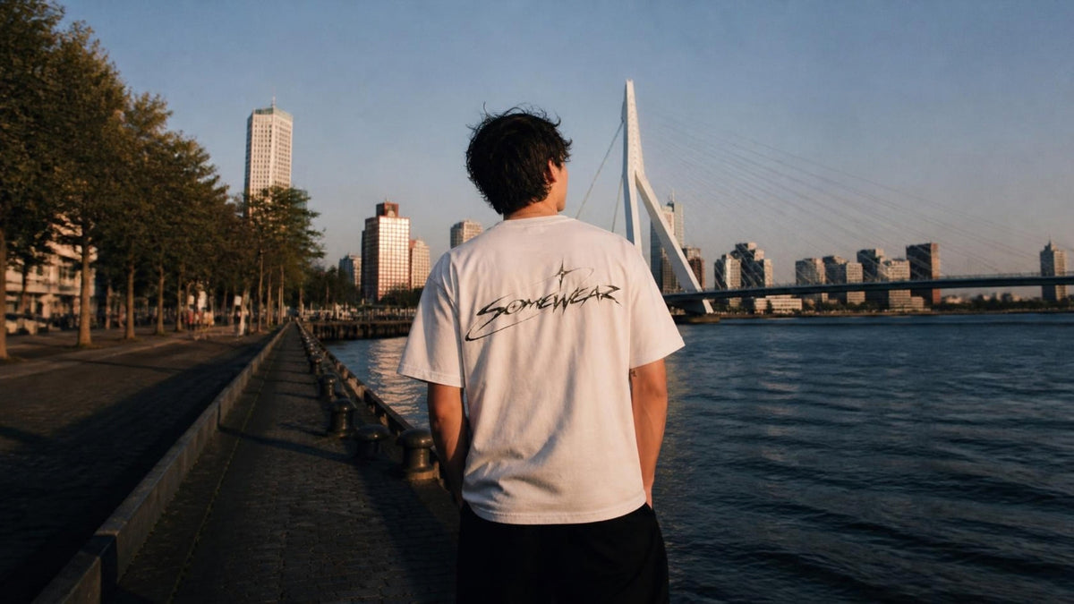 Somewear white tee with the script back logo on the Rotterdam waterfront at golden hour